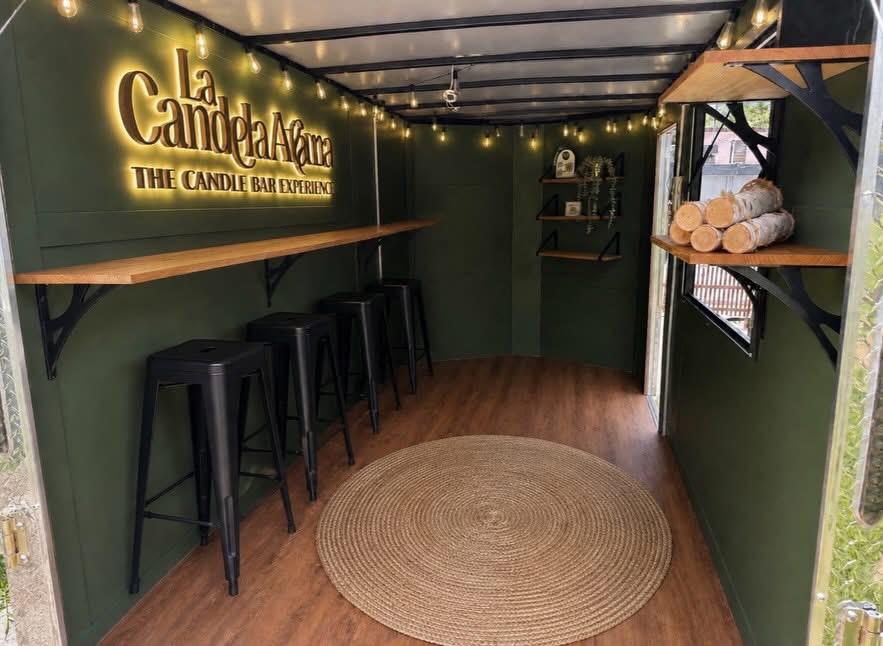 Interior del Mobile Candle Bar con barra de madera y banquetas