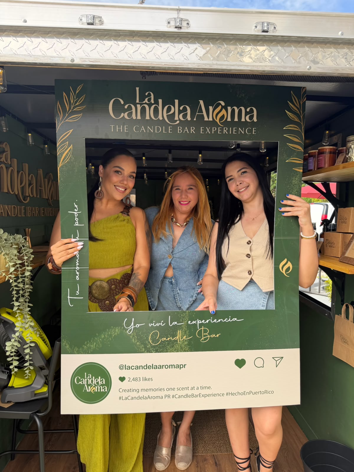 Tres clientes posando con el marco de La Candela Aroma PR durante la experiencia VIP